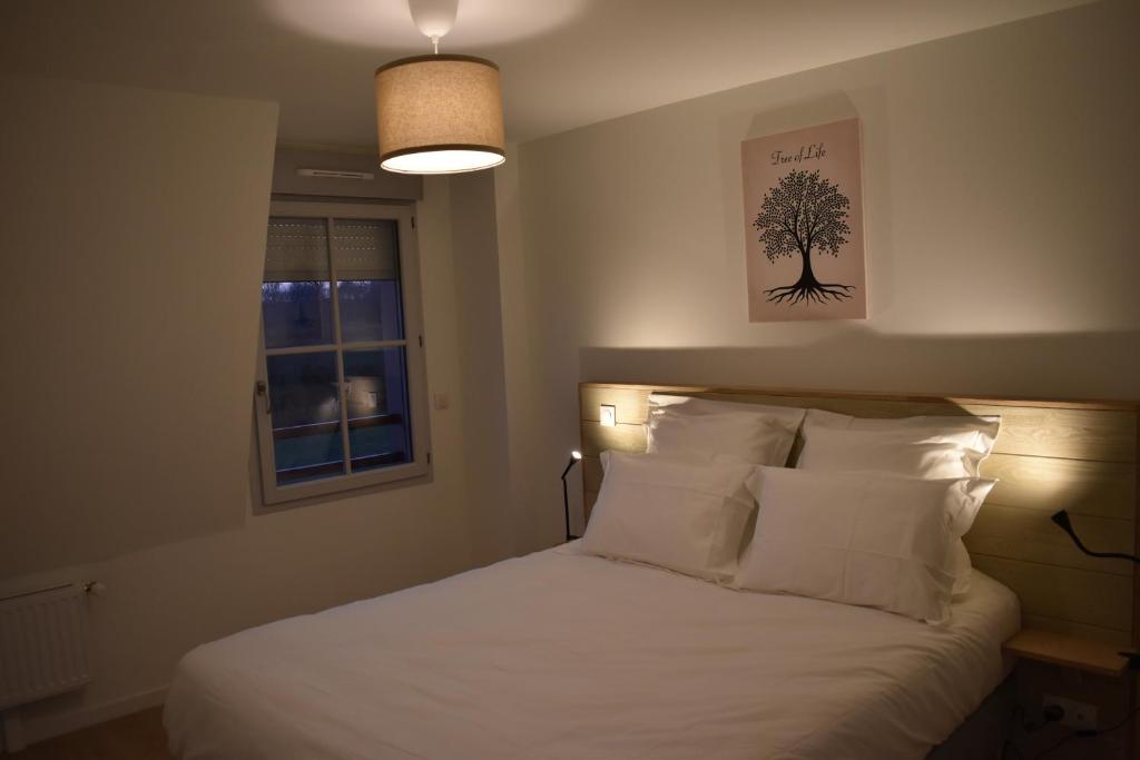 - une chambre dotée d'un lit avec une photo d'arbre sur le mur dans l'établissement Le Saint Pierre en Baie Appt 3-4 pers parking privé, à Saint-Valery-sur-Somme