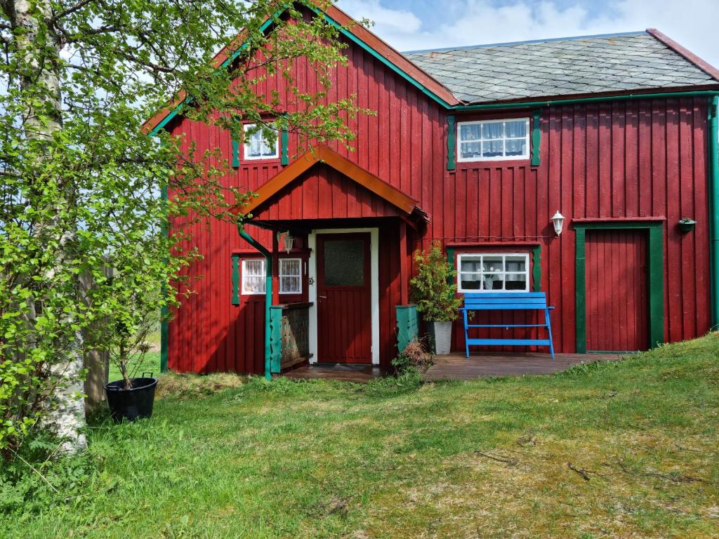 a red barn with a red door at Polar Cottage House Bodø in Nygårdsjøen