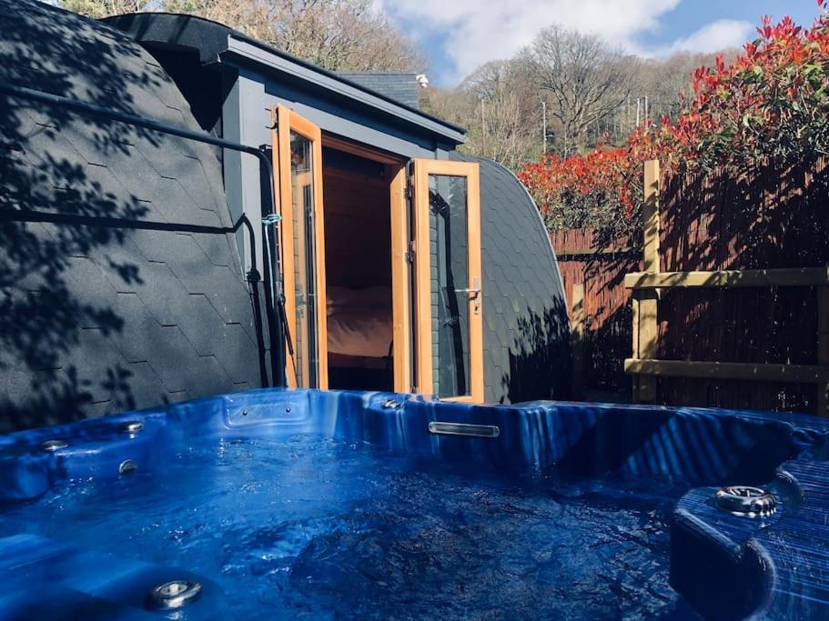 una gran bañera azul frente a una casa en River Side Cabin with Hot tub Snowdonia, en Barmouth