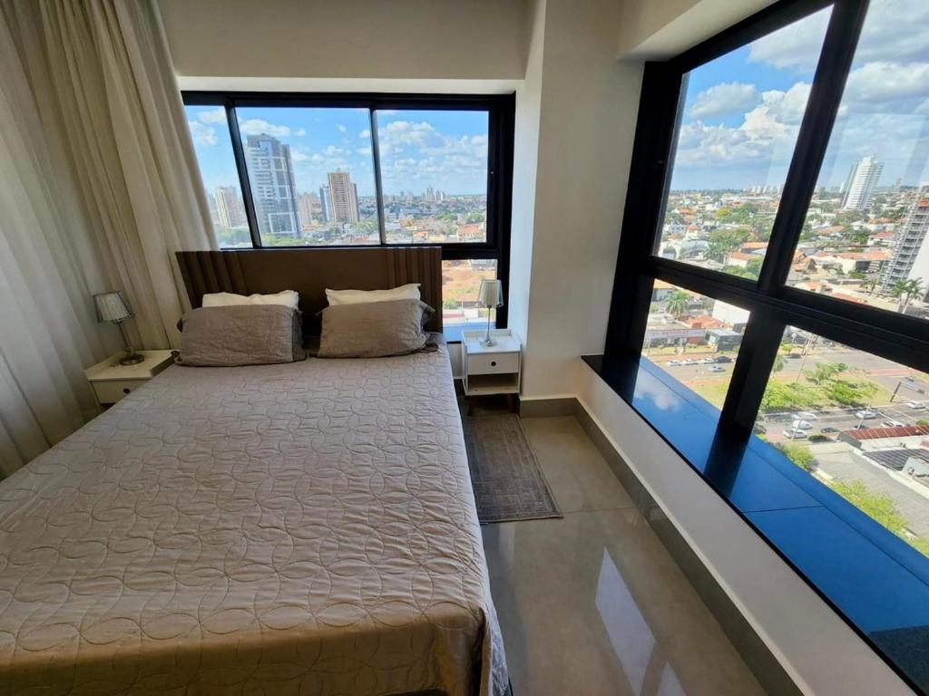 a bedroom with a bed and large windows at A Melhor Vista de Campo Grande in Campo Grande