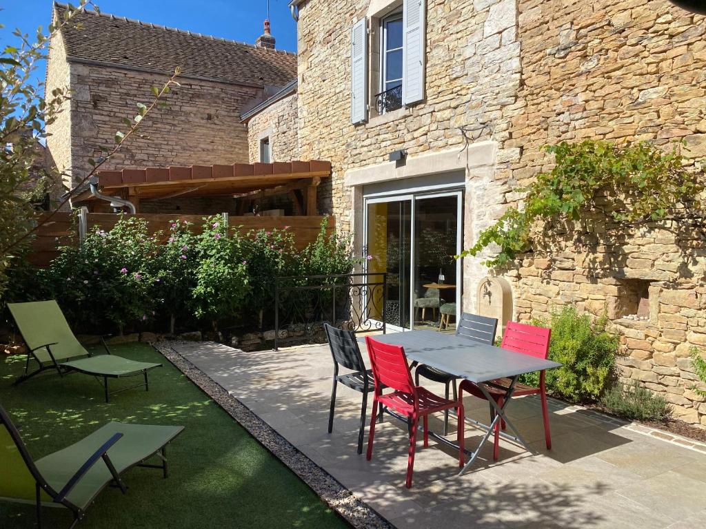 eine Terrasse mit einem Tisch und Stühlen vor einem Gebäude in der Unterkunft Coeur de Pommard in Pommard