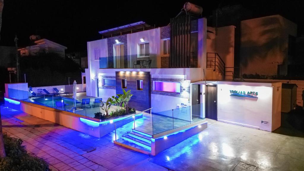 uma casa é iluminada com luzes azuis e roxas em Tsolias Apartments em Protaras