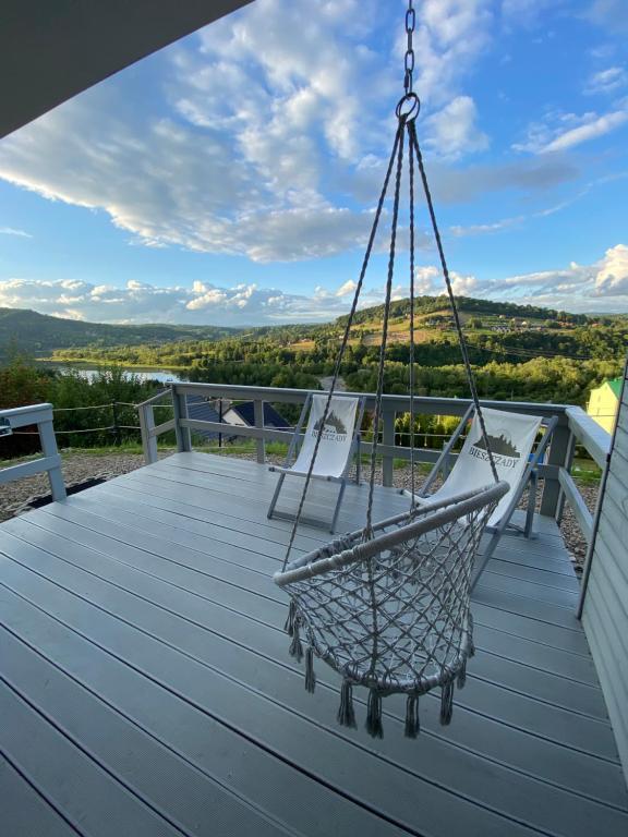 a swing on the deck of a house at Amaretto Apartamenty-Solina z sauną i ruską banią in Solina