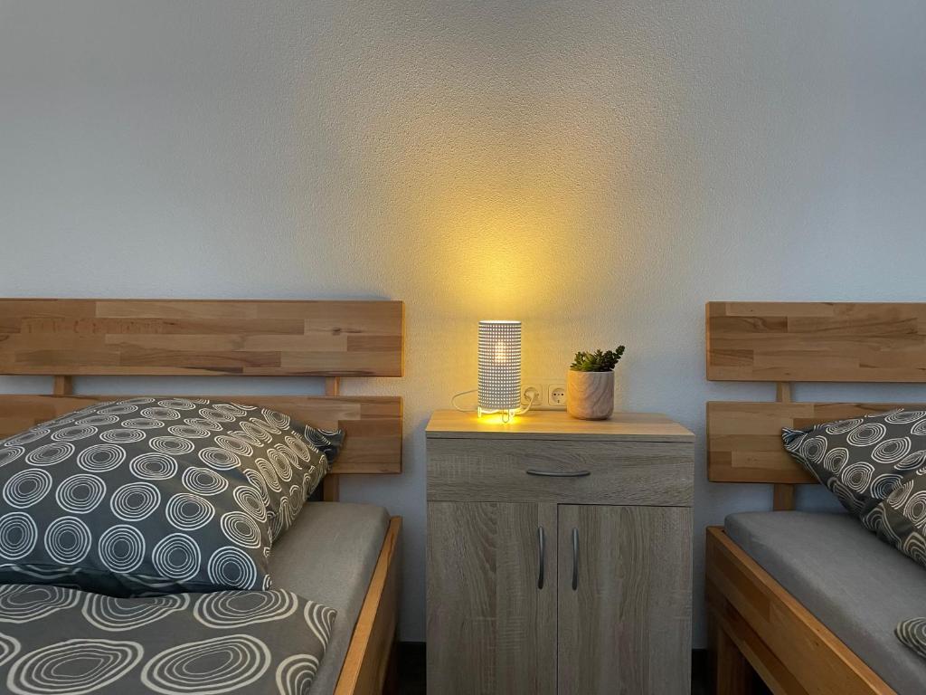 een slaapkamer met een bed en een nachtkastje met een lamp bij Lora Appartements in Mainbernheim