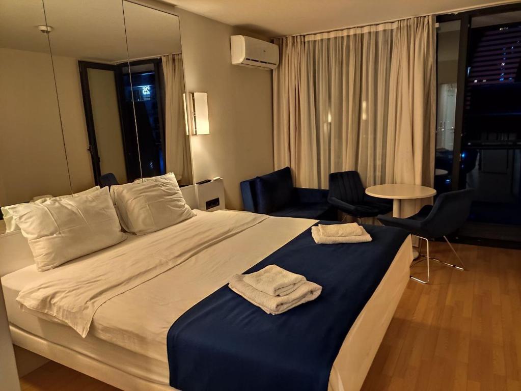 a hotel room with a bed with two towels on it at ORBI CITY in Batumi