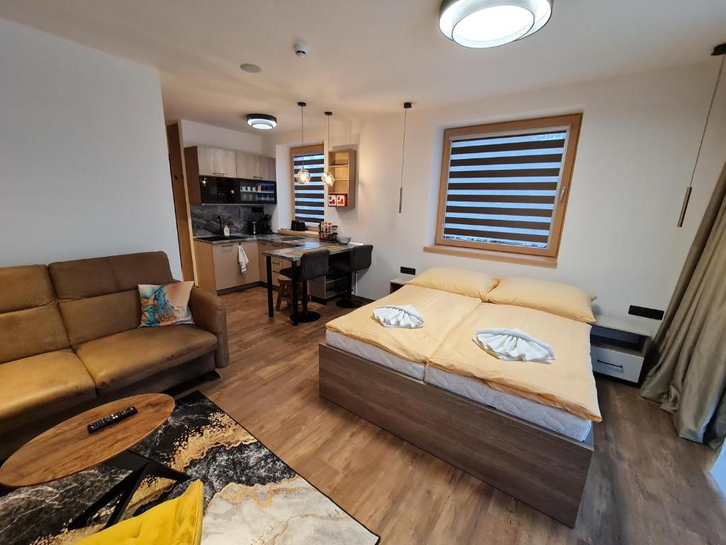 1 dormitorio con 1 cama y 1 sofá en Apartman Veka-Hotel Ovruč, en Vysoké Tatry