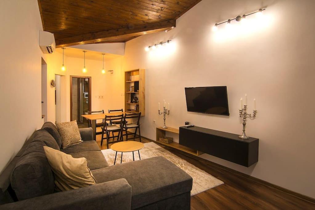 sala de estar con sofá, TV y mesa en Retro Apartment 11, en Plovdiv