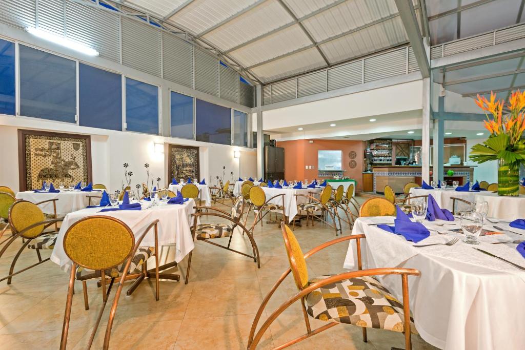 a banquet hall with tables and chairs with blue napkins at Hotel Dann Combeima in Ibagué