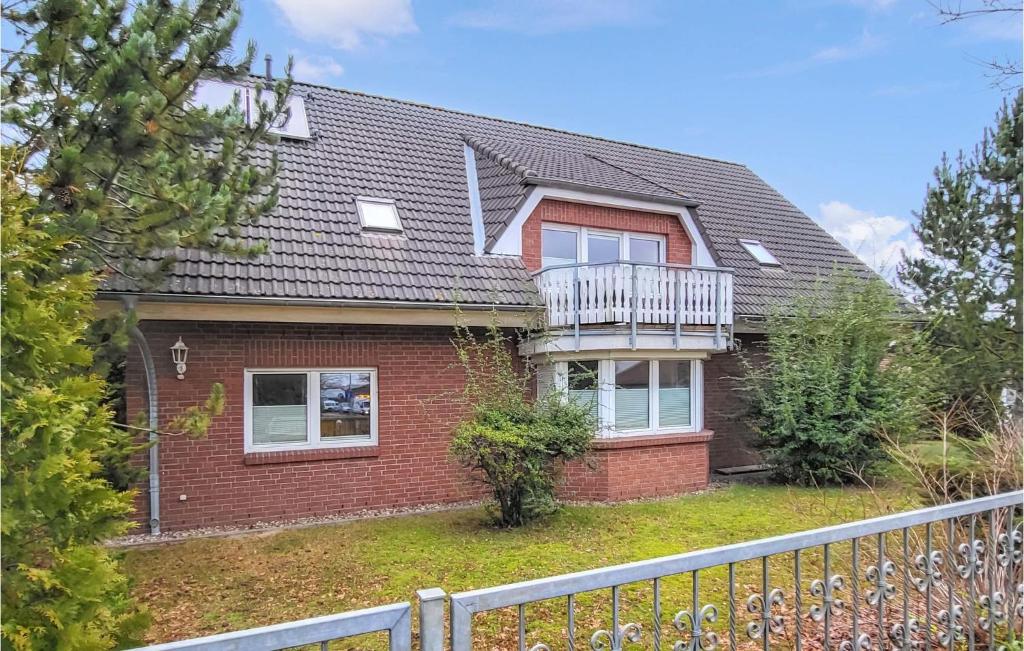 a red brick house with a balcony on it at Pension Kuestenbrise in Elmenhorst