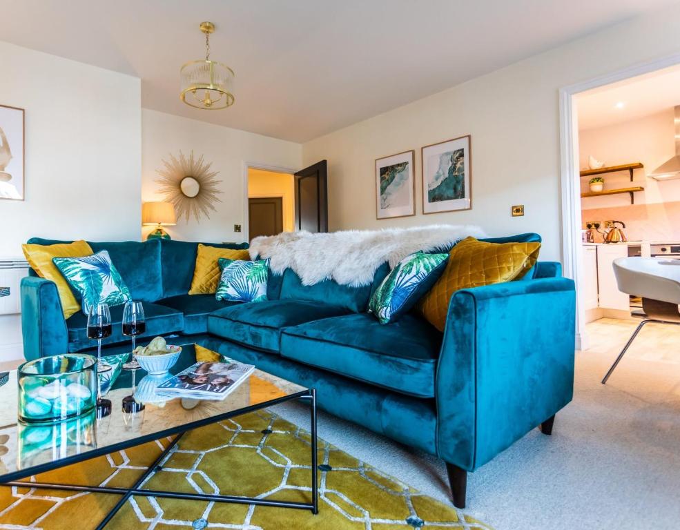 Sofá azul en la sala de estar con mesa en Bright, immaculate, luxe Apartment minutes from Warwick - perfect for short & long breaks, en Warwick