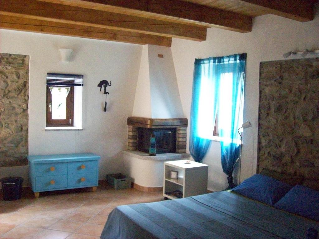 a bedroom with a blue bed and a fireplace at Appartamenti Cà di pom in Omegna