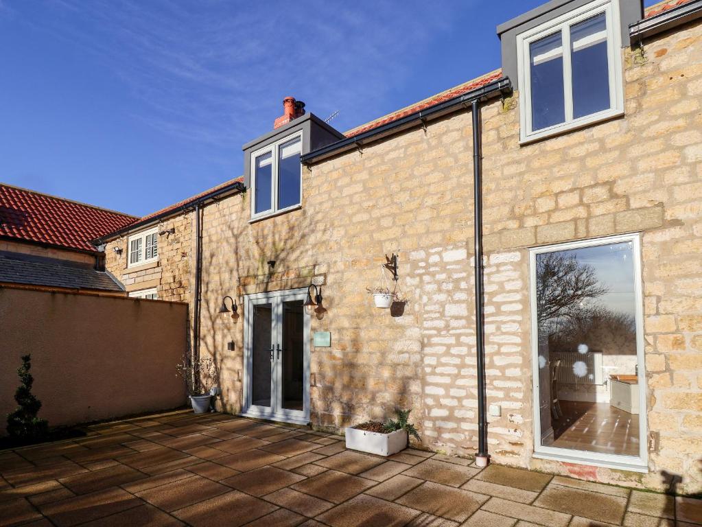 a brick house with a large patio in front of it at The Pheasantry in Scarborough