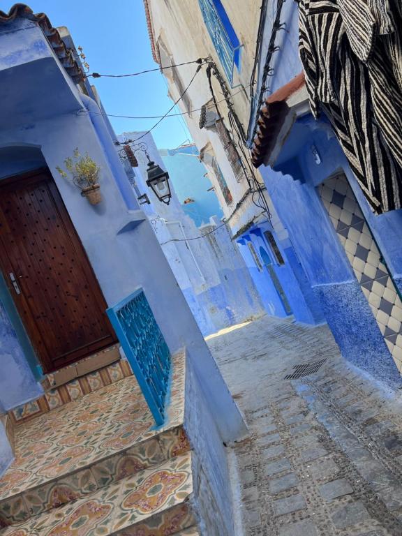 - un bâtiment bleu avec une porte et des escaliers bleus dans l'établissement La Perla Azul, à Chefchaouen