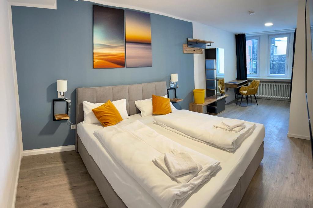 a bedroom with a large bed with yellow pillows at Aparthotel Neumünster City in Neumünster