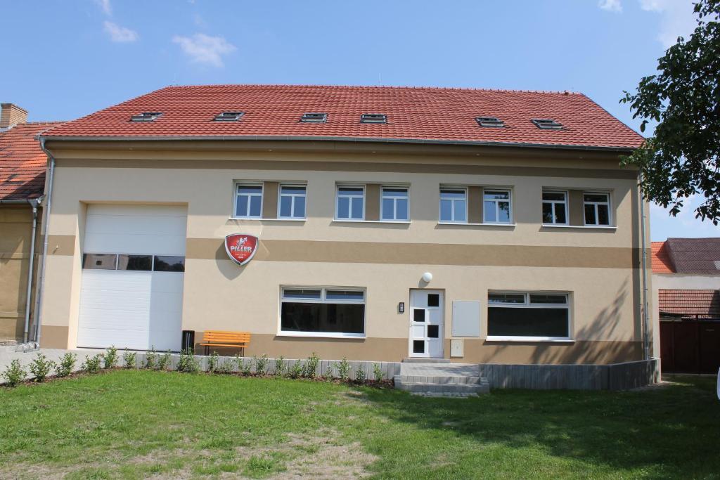 una casa grande con techo rojo en Guesthouse Piller, en Chvalín