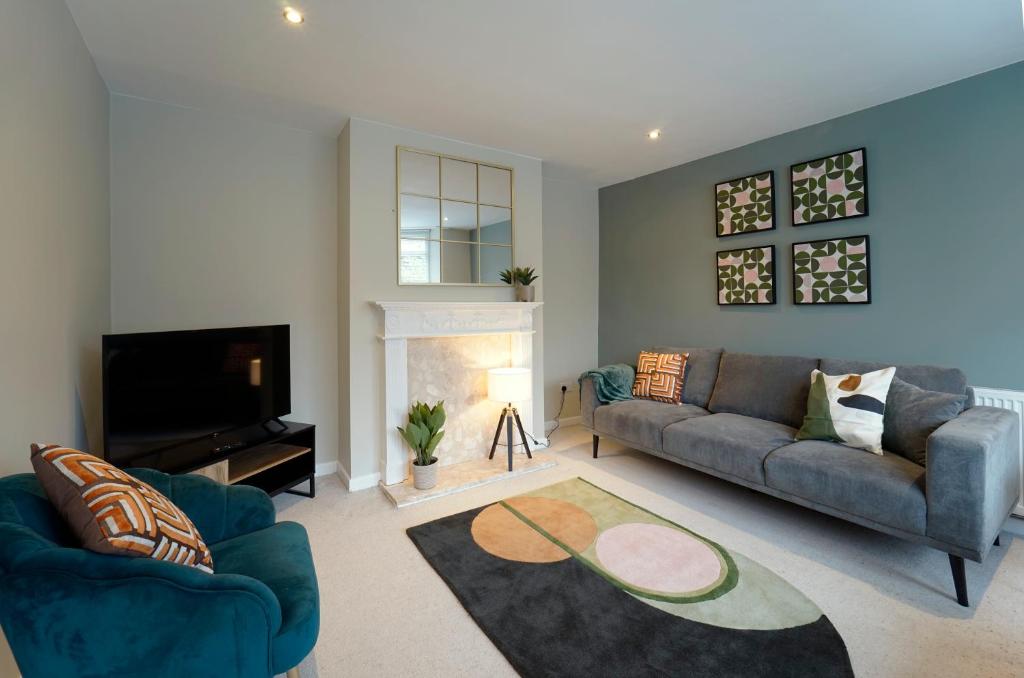 sala de estar con 2 sofás azules y chimenea en Perfectly located 4 bed town house in central Wetherby sleeps 8 en Wetherby