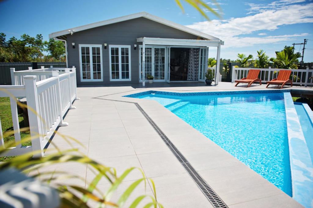 a swimming pool in front of a house at Joe's Shack - A cosy oasis in Nadi close to the beach, supermarkets, restaurants, Denarau Island and the Marina. in Nadi