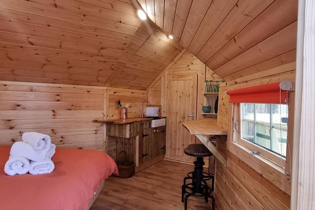 a bedroom with a bed in a wooden cabin at Tree Top Cabin with log burner & private hot tub in Barmouth