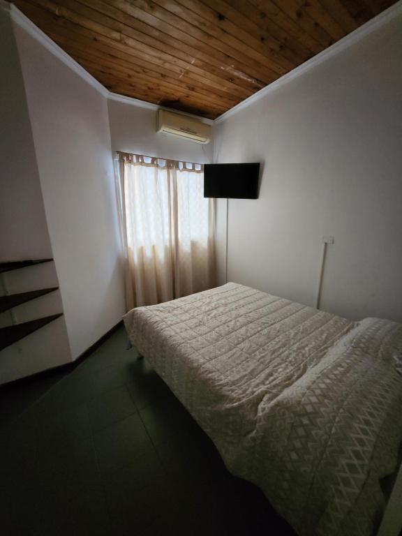 1 dormitorio con 1 cama con techo de madera en Departamento ubicadisimo con estacionamiento incluido capital Mendoza 5 en Mendoza