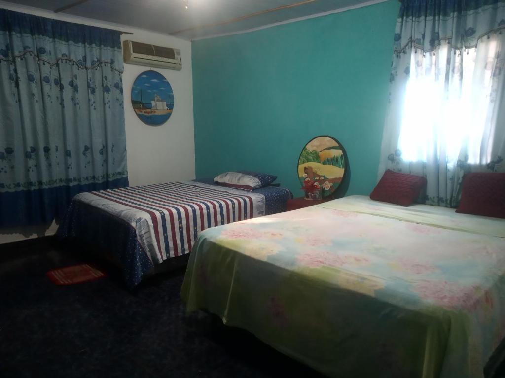 2 Betten in einem Zimmer mit blauen Wänden in der Unterkunft Grahl house in Encarnación