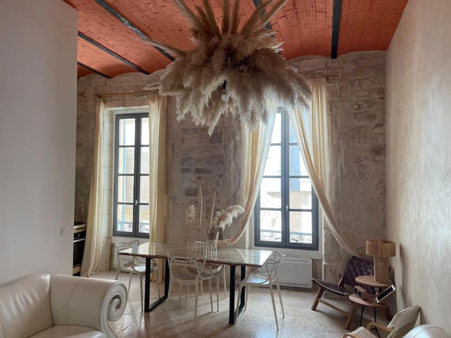 un salon avec une table et un lustre dans l'établissement Pamp’Arles, à Arles