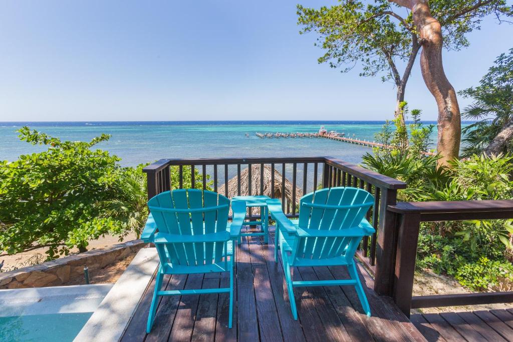 two chairs and a table on a deck overlooking the ocean at Casa de Suenos Home in Sandy Bay