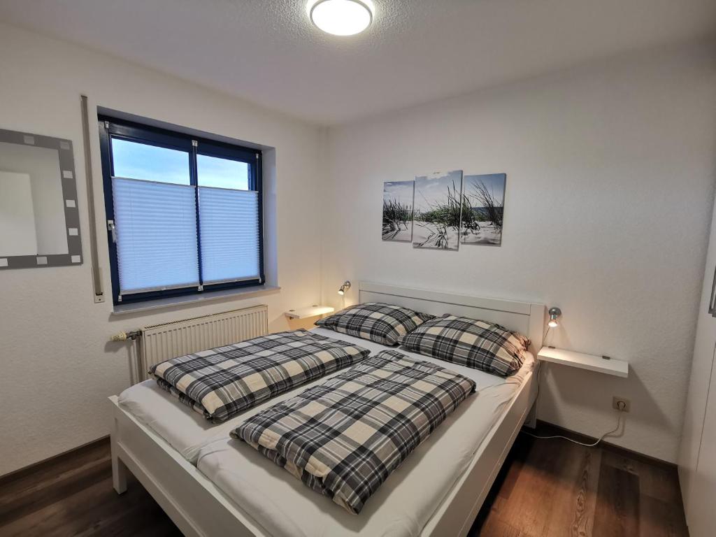 um quarto com 2 camas e uma janela em Strandsegel em Horumersiel