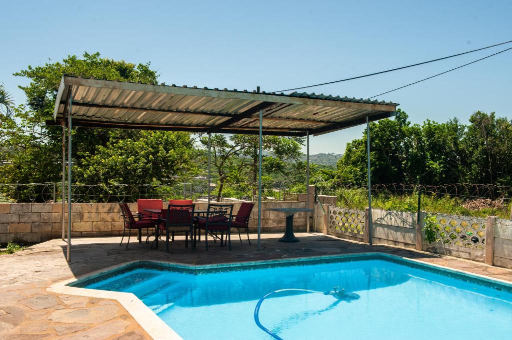 a patio with a table and chairs next to a swimming pool at Nkosazana Guest House in Durban