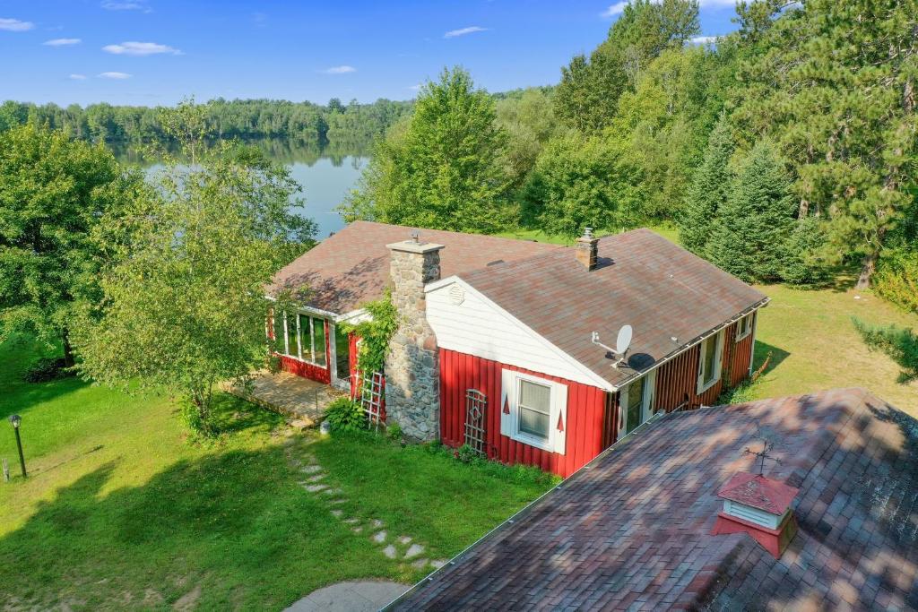 an aerial view of a red house with a lake at Scenic & Serene Lakefront Cottage With Wood Stove in Crivitz