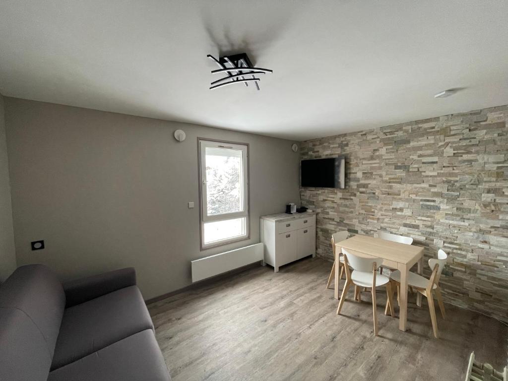 un salon avec un canapé et une table dans l'établissement Appartement 4 personnes aux pieds des pistes Wifi Netflix, à Les Deux Alpes