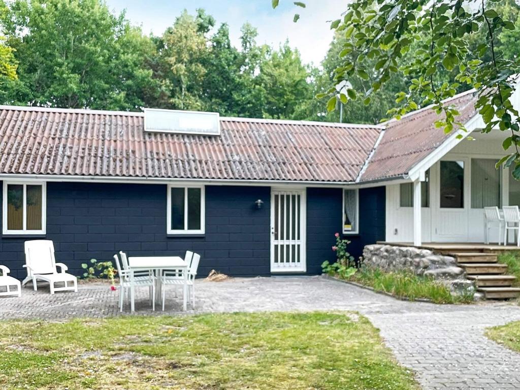 a blue house with a table and chairs in front of it at 6 person holiday home in Hadsund in Odde
