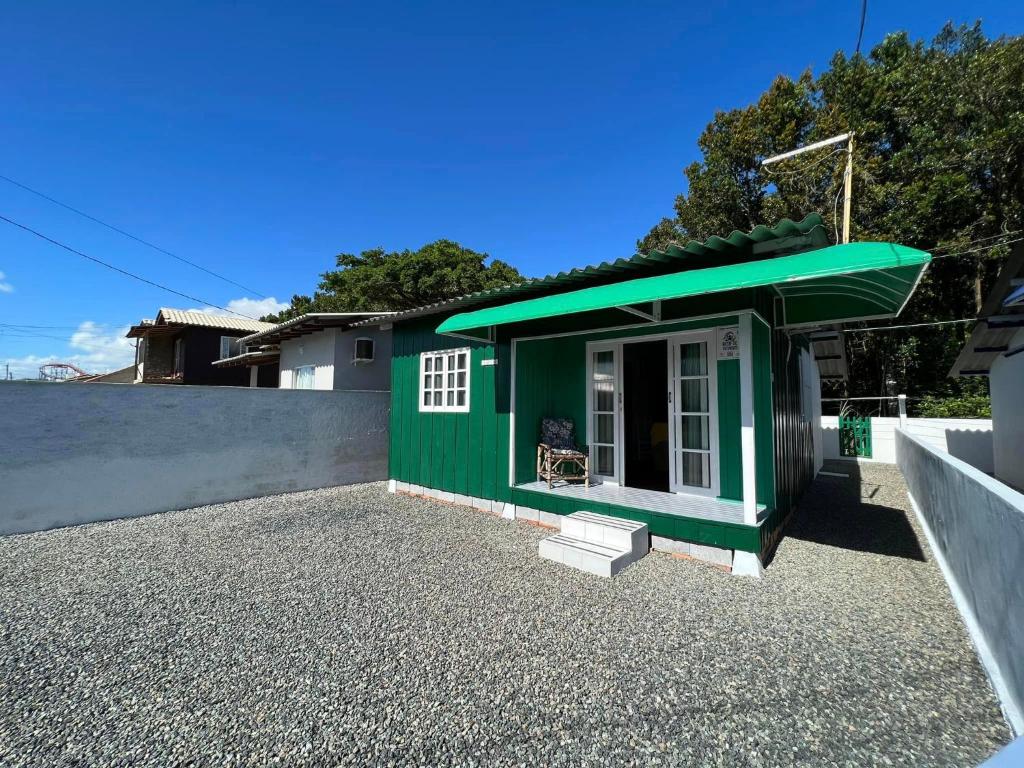 a green tiny house sitting on top of a driveway at CASA SUZENA - Penha SC a 300 metros do Beto Carrero e Praias in Penha