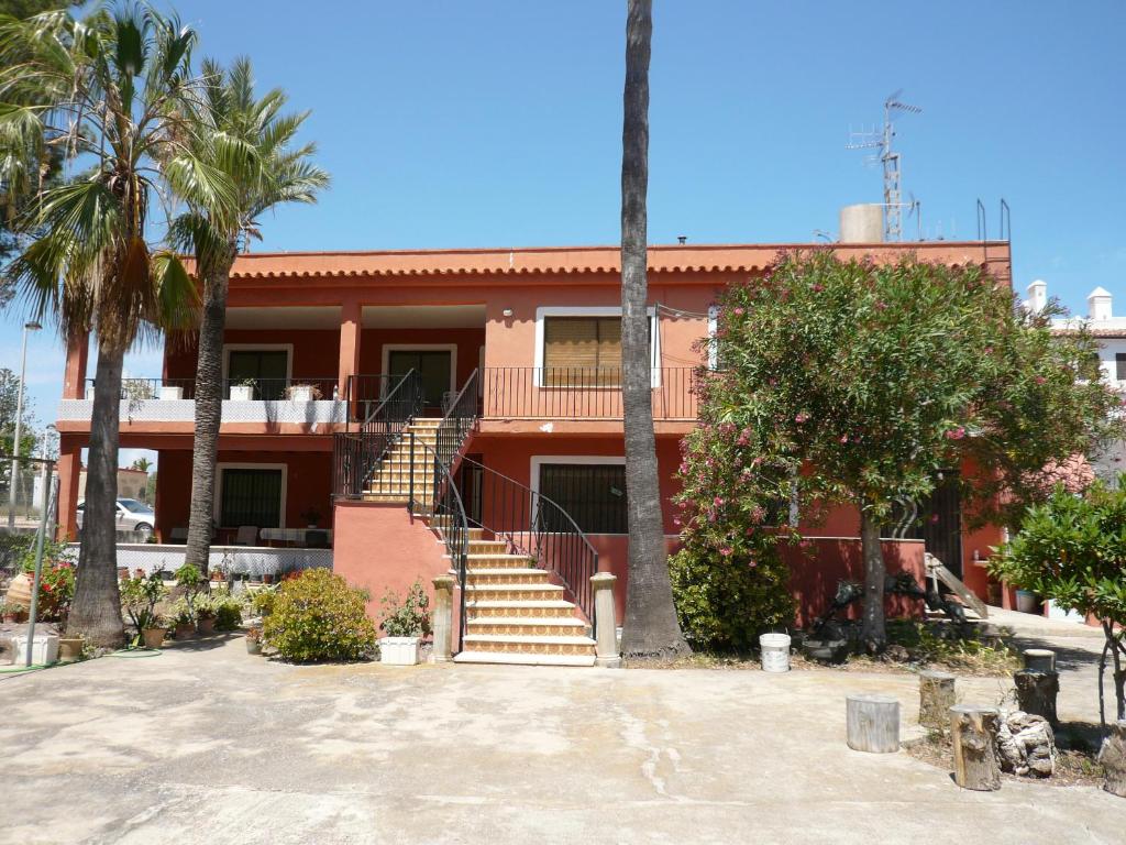 a house with stairs and palm trees in front of it at CASA INOCENCIA in Alcossebre