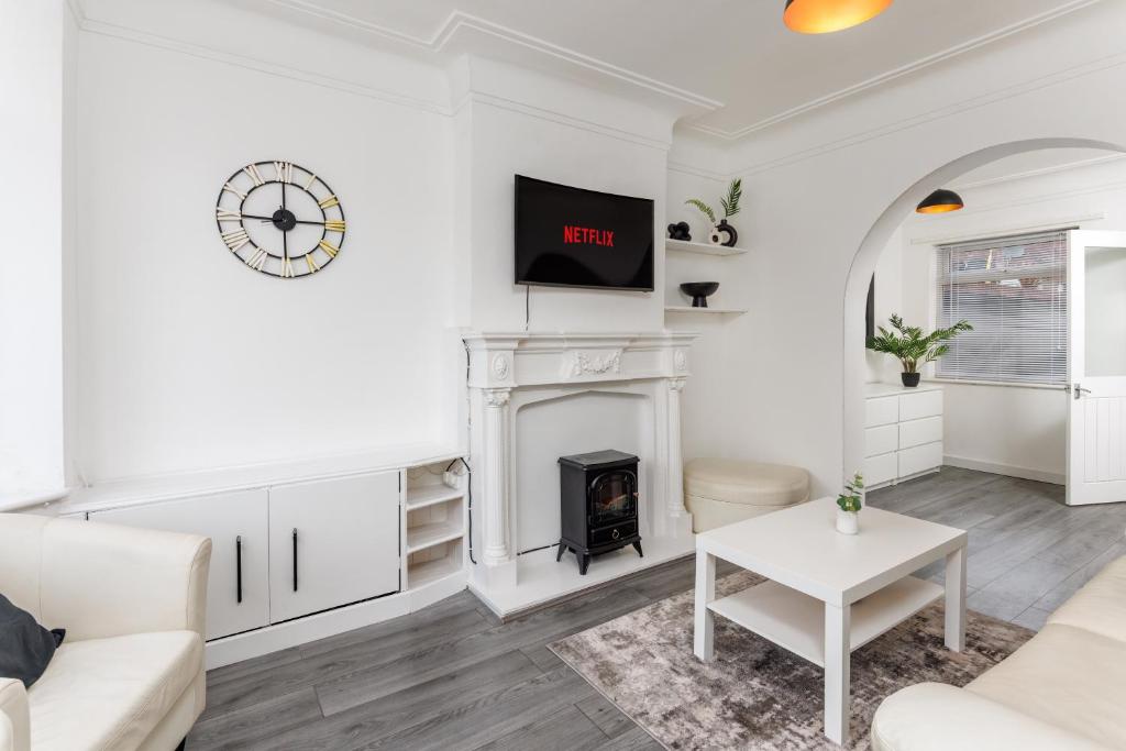 a living room with white furniture and a fireplace at The Empress 2 Bed Terraced House in Liverpool