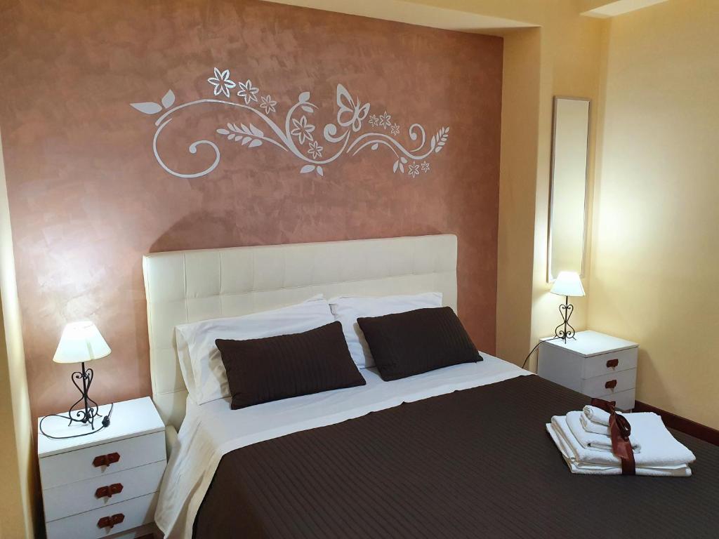 a bedroom with a black and white bed with two night stands at Casa La Ferula apt1 vicino al mare e Taormina in SantʼAlessio Siculo