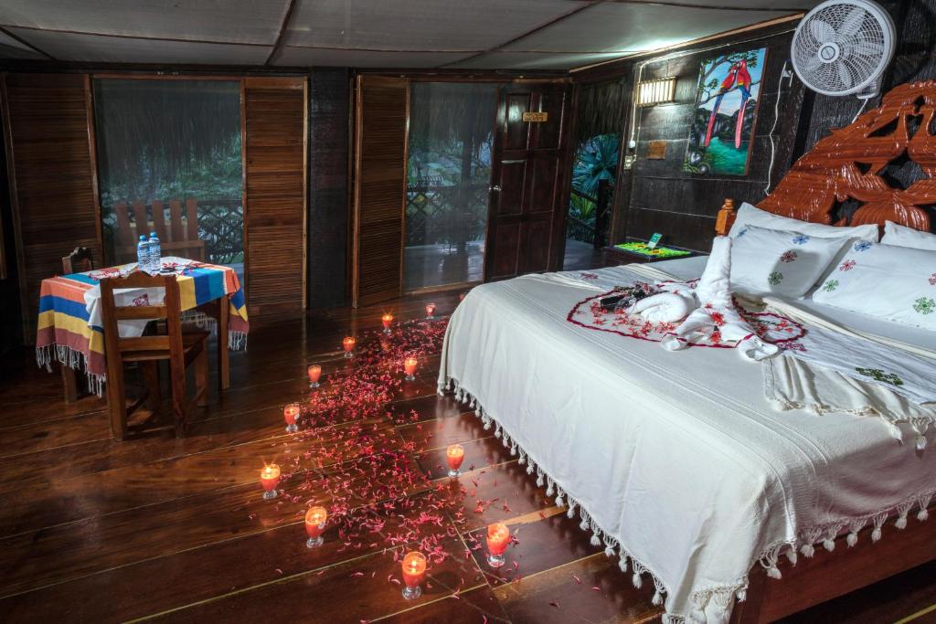 Las Guacamayas Lodge Resort, Selva Lacandona, Chiapas México في Tlatizapán: غرفة نوم بسرير مع شموع على الارض