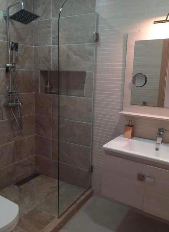 a bathroom with a shower and a toilet and a sink at Karate in Kent