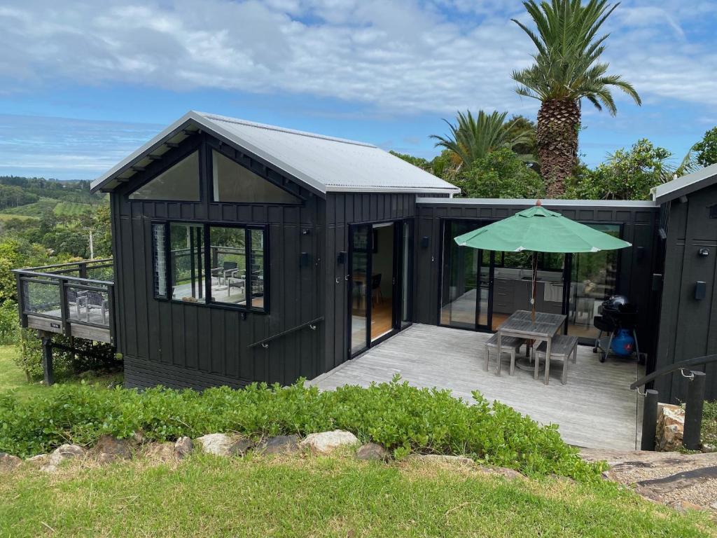 a black shed with a table and an umbrella at Art Lovers Retreat in Onetangi