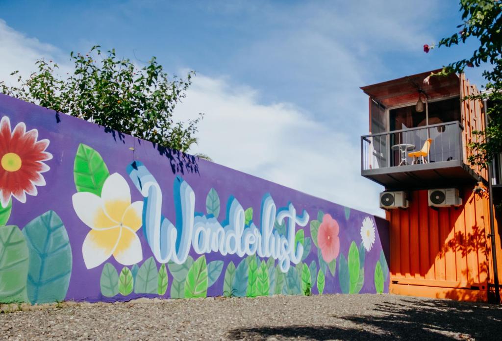 a wall with a mural of flowers on it at Wanderlust in Jacó