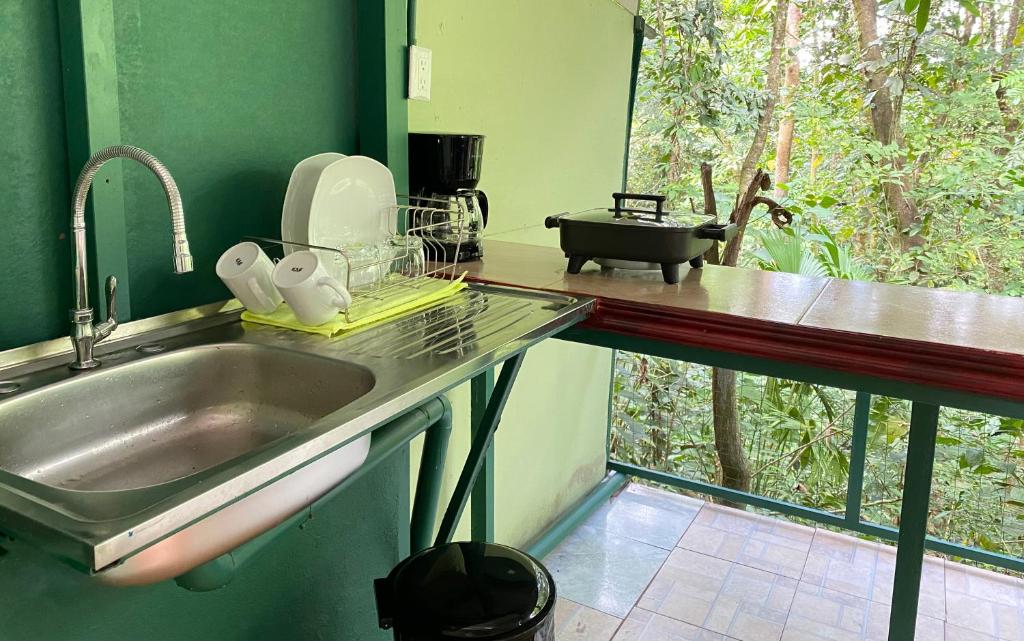 un comptoir de cuisine avec un évier et une fenêtre dans l'établissement Grettel´s House Apartments, La Fortuna de San Carlos, à Fortuna