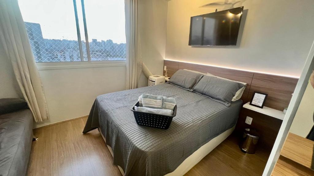 a bedroom with a bed with a television on the wall at MV 148A Espetacular Apartamento Em Frente Ao Metrô Brás ! - Rua Coronel Mursa, 56 - Bras in Sao Paulo