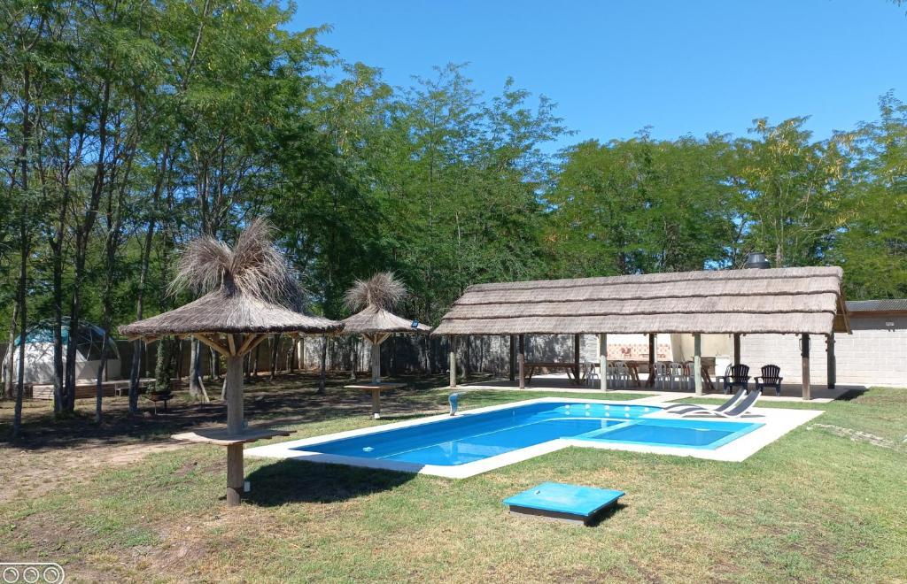 a swimming pool with an umbrella and a pavilion at La Yuma en Villars in Villars