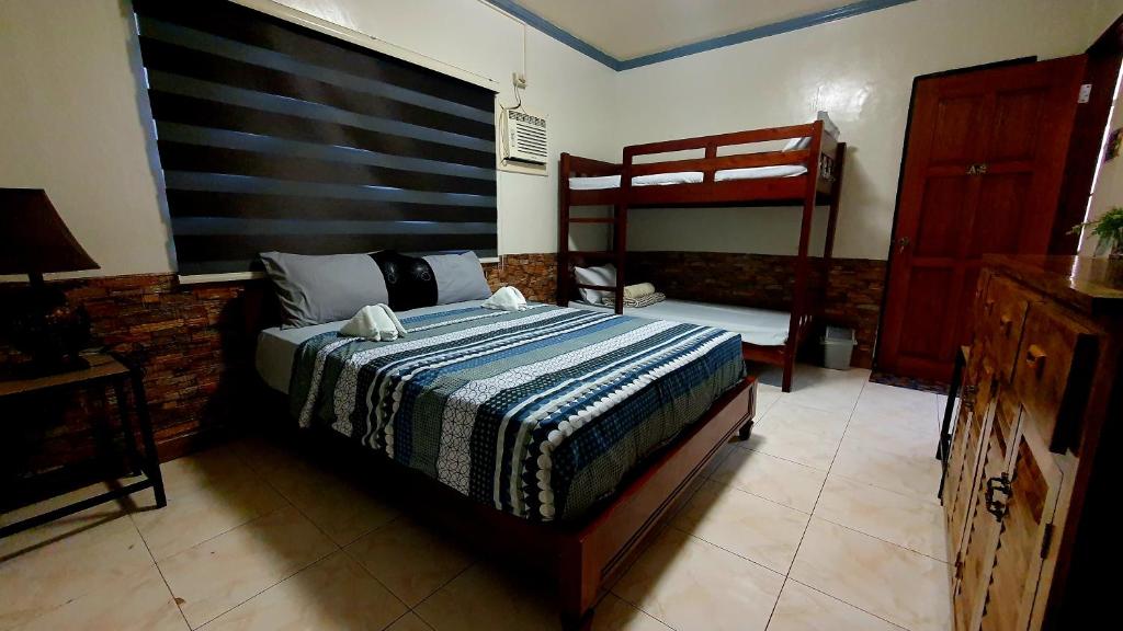 a bedroom with a bed and a bunk bed at UNK'S HOUSE HOMESTAY in Panglao Island