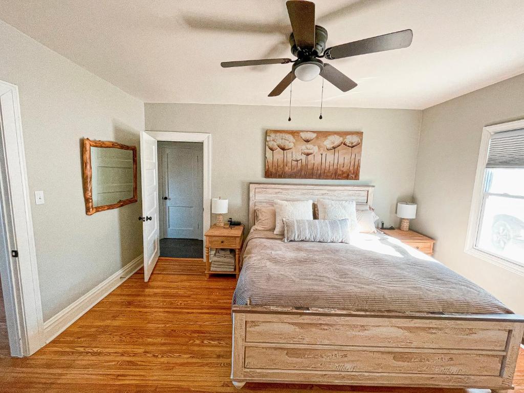 ein Schlafzimmer mit einem Bett und einem Deckenventilator in der Unterkunft Spotless, Comfortable home with Hot Tub! in Fieldale