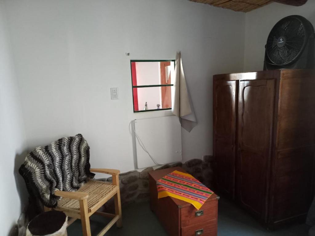 sala de estar con silla y ventana en Cabaña Los Girasoles Cachi Salta en Cachí