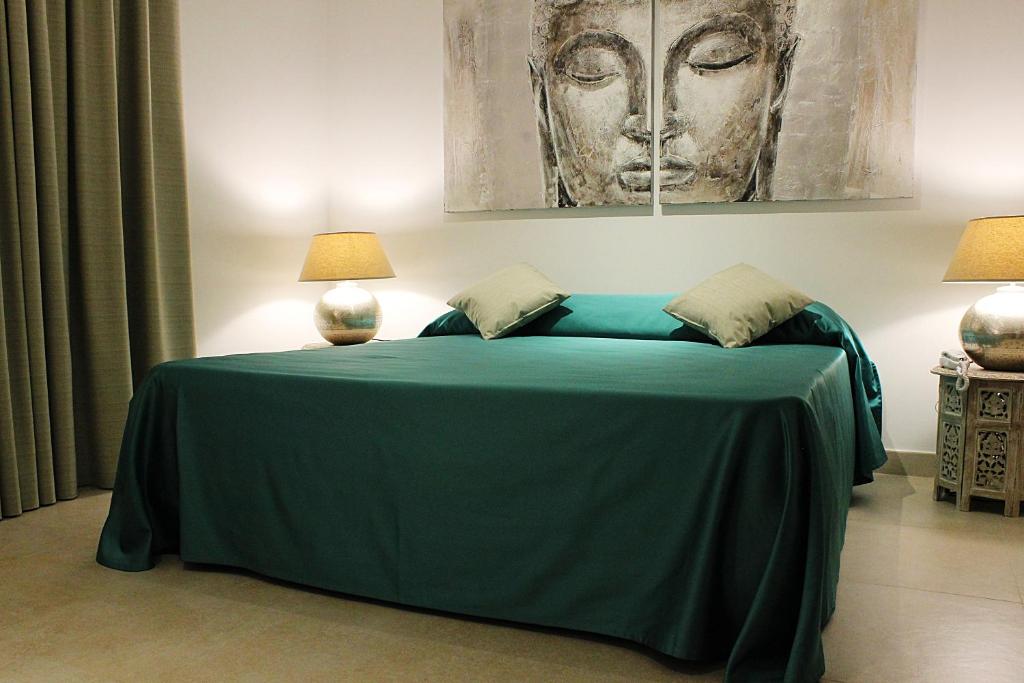 Un dormitorio con una cama verde con una pintura en la pared en L'Etoile, en Foggia