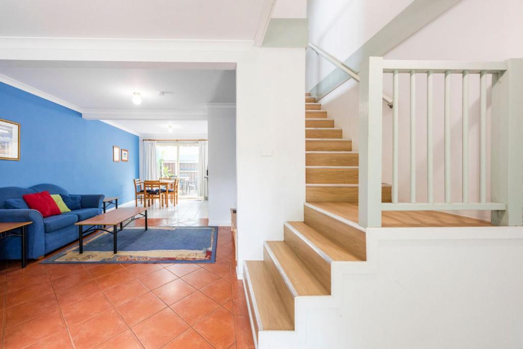 a staircase in a living room with a blue wall at Clifton on Charles in Iluka