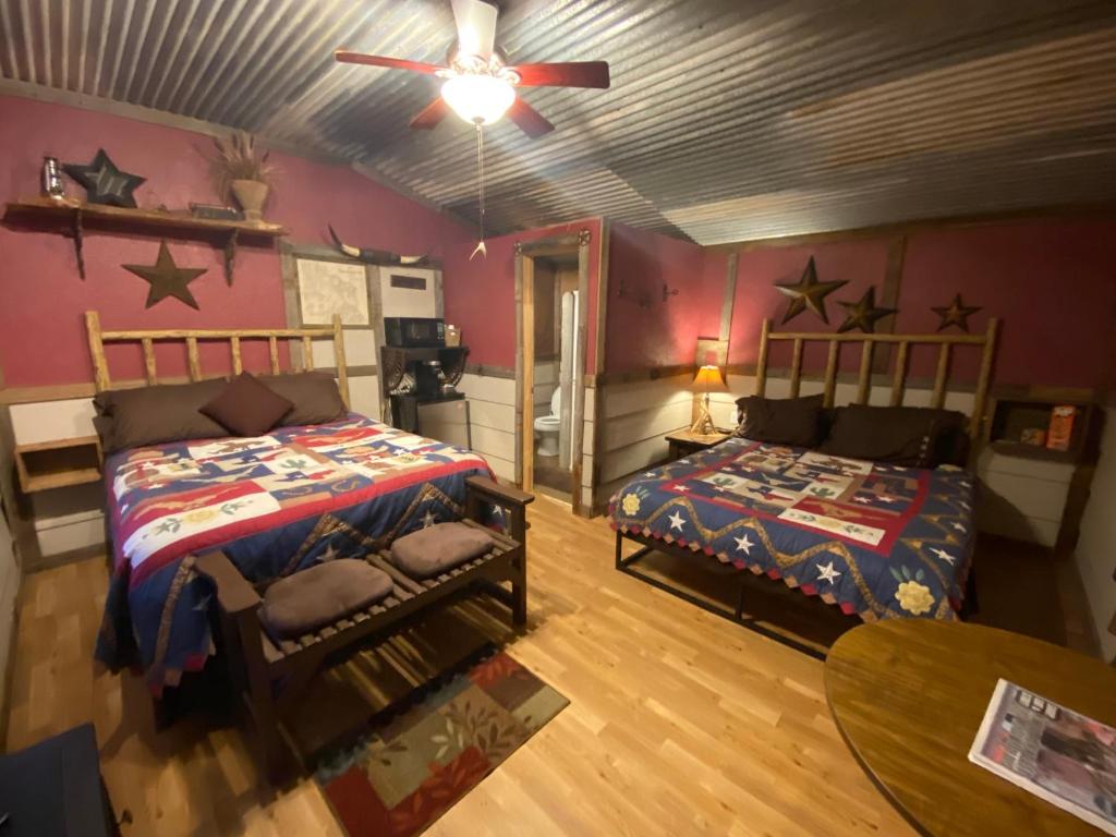 - une chambre avec 2 lits et un ventilateur de plafond dans l'établissement Acorn Hideaways Canton Cozy Frontier Suite 1890s Cattle & Land Decor, à Canton