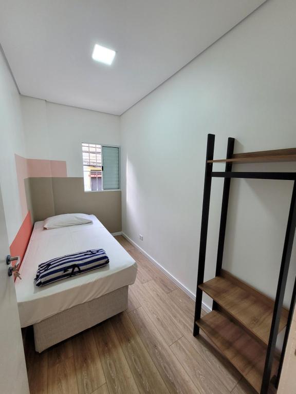 um quarto com uma cama e piso em madeira em Self Hostel em São Paulo