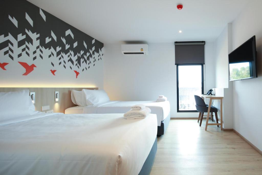 Habitación de hotel con 2 camas y escritorio en KOO HOTEL, en Ban Bang Talat